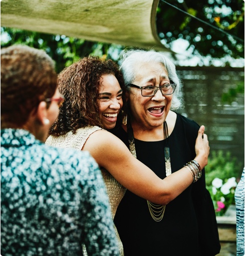 granddaughter hugging grandmother laughing